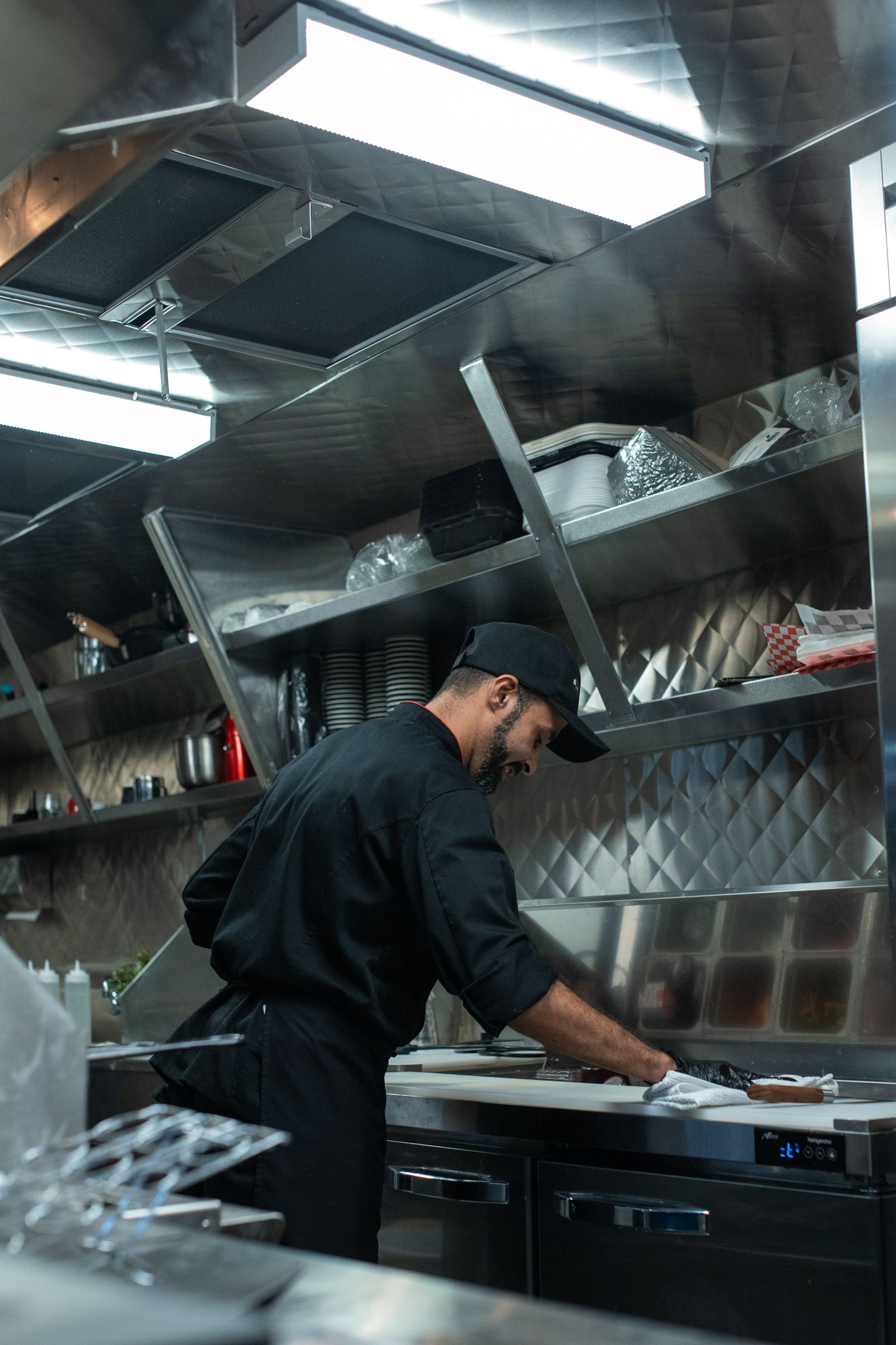 Cozinha profissional com bancadas e prateleiras em aço inox